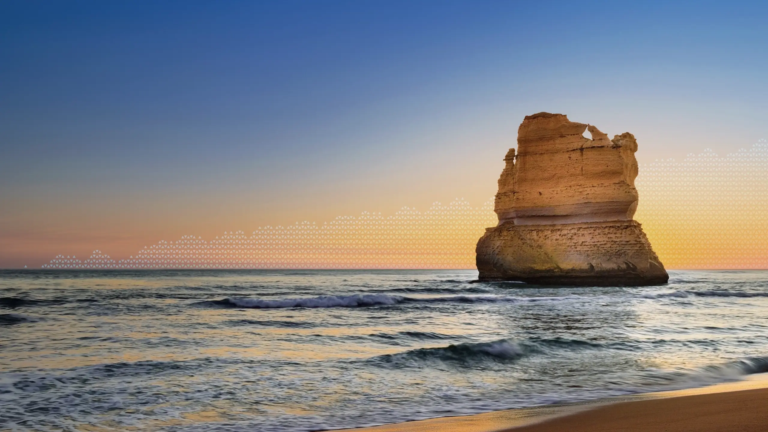 Calm seascape at golden hour with a rock emerging from the water. 